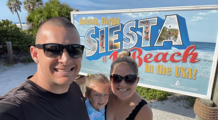 Holly's son with his family in front of a Siesta Beach sign