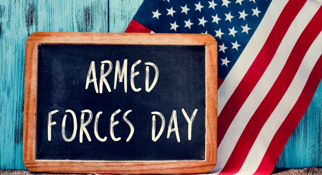 An American flag behind a chalkboard that reads "Armed Forces Day."