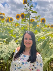 Daniella, standing in a field of sunflowers