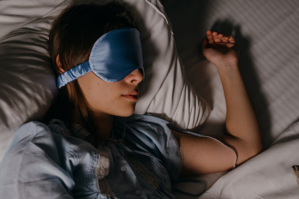 A woman using a sleep mask