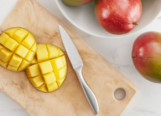 A sliced mango on a wooden cutting board