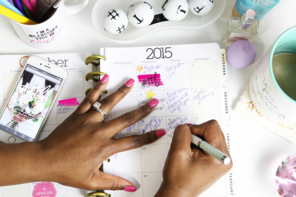A woman adding to her monthly calendar