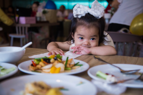 A little girl sitting at a table in a restaurant