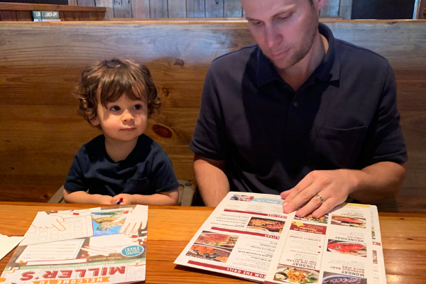 Ana-Sofia's husband and son looking at menus at Miller's Ale House