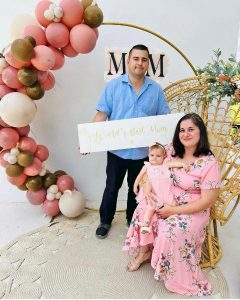 Rachel poses for a picture with her husband and infant daughter
