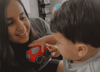 Daniella and Enzo playing with a red car.
