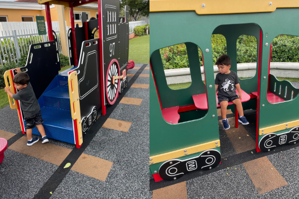 A little boy playing on a train at a local playground