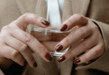 A corporate woman holding a glass of water