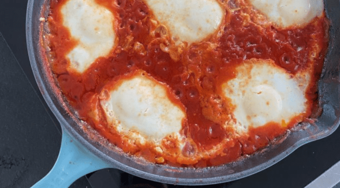 A pan of marinara sauce and mozzarella cheese
