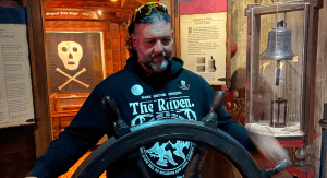 A man stands at the helm at the pirate museum