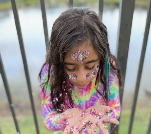A little girl with a handful of glitter. She felt free after her dyscalculia diagnosis.