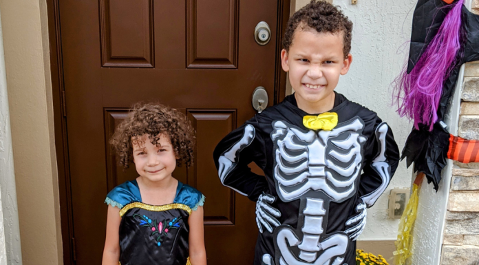 Two kids pose for a picture in their Halloween costumes