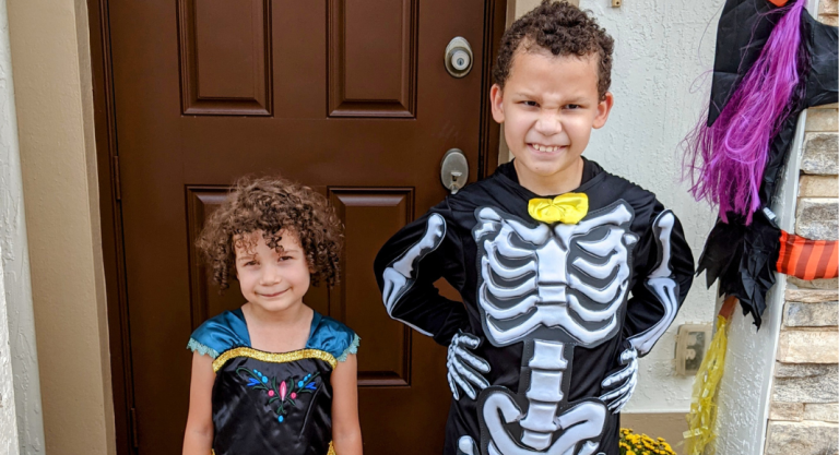 Two kids pose for a picture in their Halloween costumes