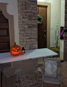 A jack o' lantern and other Halloween decorations set up for trick or treaters