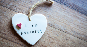 A ceramic heart ornament that reads, "I am grateful"