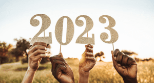 Hands holding up numbers that read 2023