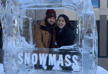 A couple poses for a picture in at ice sculpture in Snowmass, CO