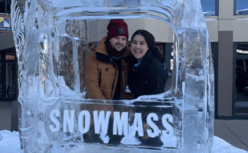 A couple poses for a picture in at ice sculpture in Snowmass, CO