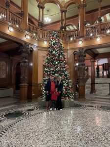 Bella and her family in front of a Christmas tree at Flagler College
