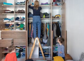 Image: A mom organizes a room while her children play