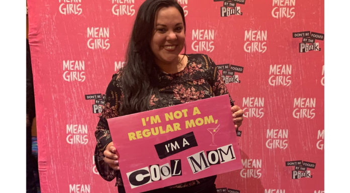 Image: Krystal holding a sign that reads, "I'm not a regular mom, I'm a cool mom."