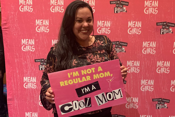 Image: Krystal holding a sign that reads, "I'm not a regular mom, I'm a cool mom."