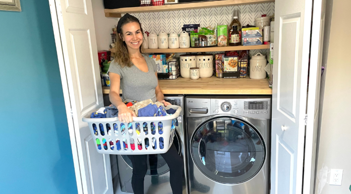 Image: Jessica stands in front of her washer and dryer with a basket of laundry
