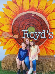 Image: Two kids and a mom sitting on a hay stack at Royd's