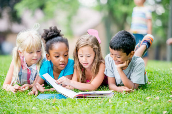 Image: Children sharing a book outside