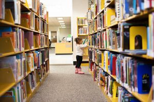 Image: A child peruses books in a library