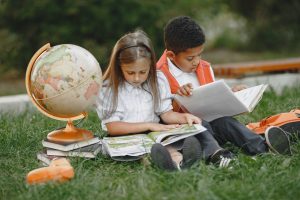 Image: Two children enjoying books outdoors