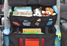 Image: A seatback organizer with water bottles, toys, and other essentials for the car