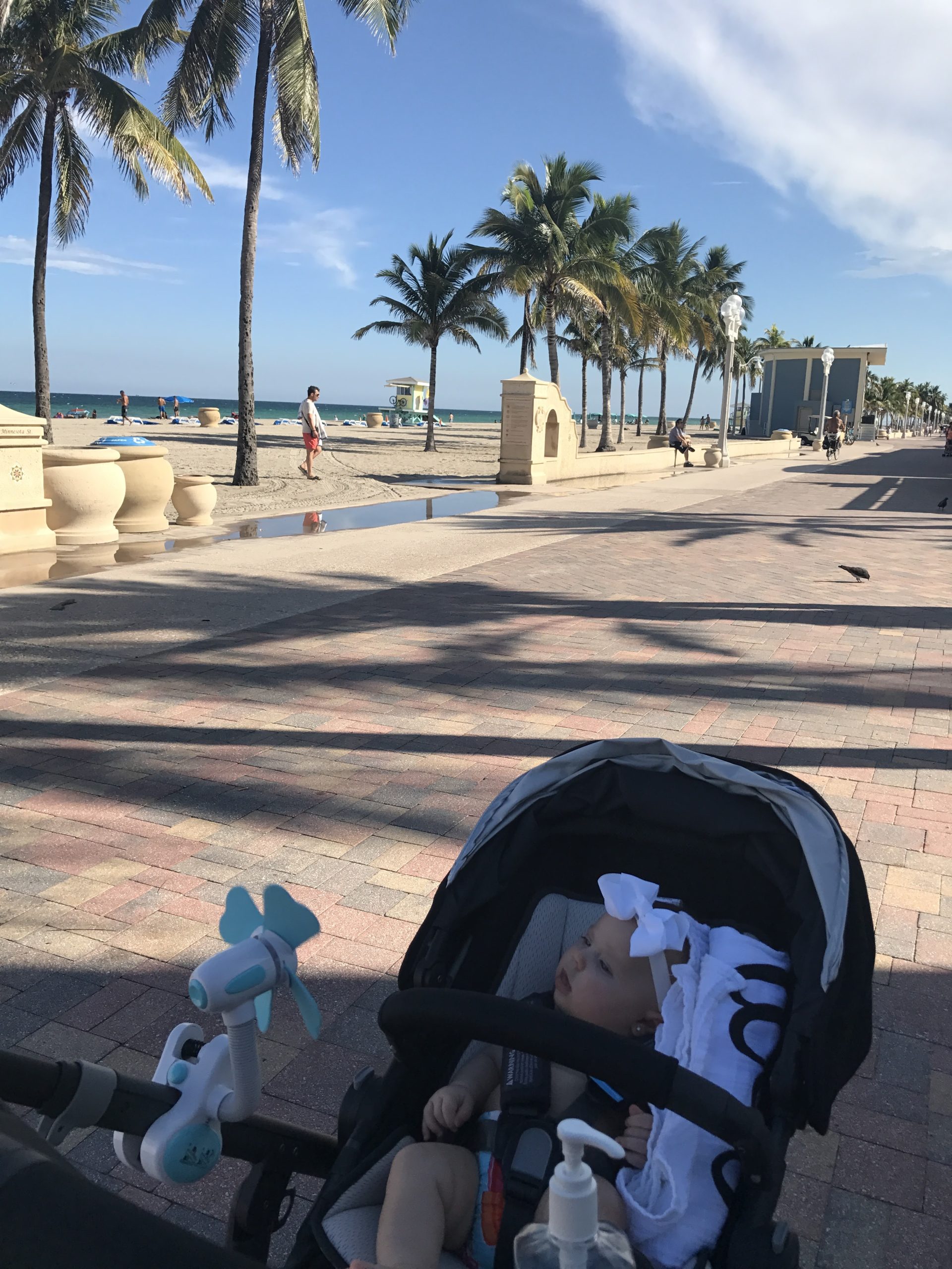 Image: An infant rides in a stroller along the boardwalk at Hollywood Beach
