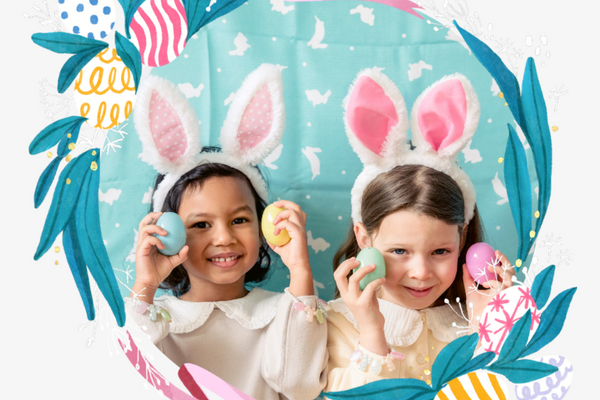 Image: Two children with Easter Bunny headbands holding colored Easter eggs