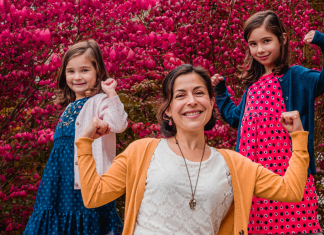Image: A mom strikes a strong pose with her daughters