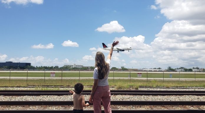 Image: A mother and son wave to an airplane as it lands at MIA
