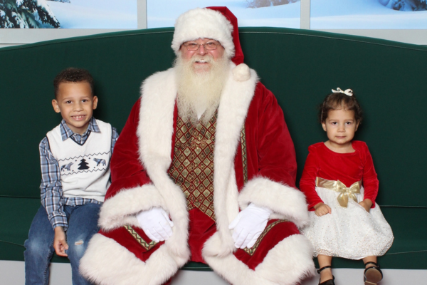 Image: Two kids sit next to Santa for a Christmas photo