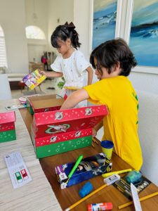 Image: Two children pack boxes for Operation Christmas Child