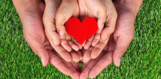 Image: Three sets of hands holding a red heart