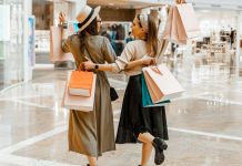 Image: 2 women carrying shopping bags while they shop together
