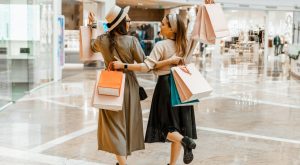 Image: 2 women carrying shopping bags and shopping together