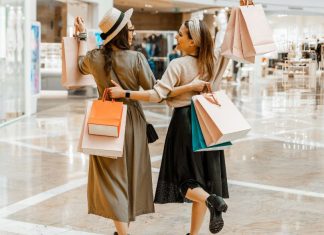Image: 2 women carrying shopping bags while they shop together