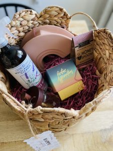 Image: An Easter basket for a young adult child filled with an all-purpose cleaner, affirmation cards, honey, honey lavender tea spoons, and a home decor item