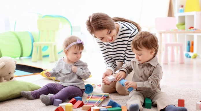 Image: A babysitter watches two toddlers play