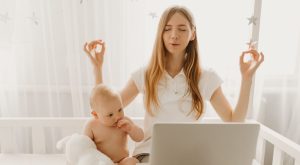 Image: A mom practices calming meditation while sitting next to her baby