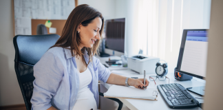 Image: An expectant mother sits at her desk at work