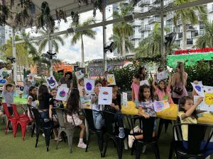 Image: Children at Miami Mom Collective's Comic Kids event hold up pictures of their squish mallows