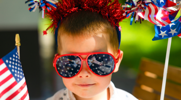 Image: A child wearing 4th of July themed sunglasses and holding flag-themed props