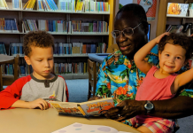 Image: A grandfather reads books to his grandchildren at the library