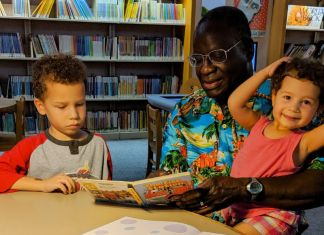 Image: A grandfather reads books to his grandchildren at the library